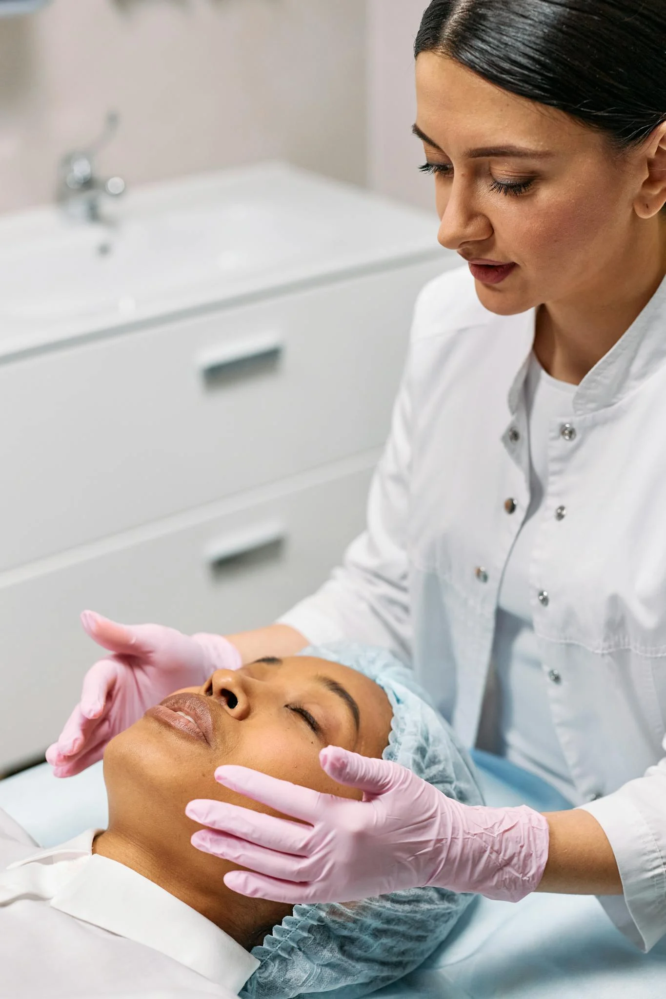 A cosmetologist cares for a client during a facial in a medical clinic. Professional beauty treatment indoors.